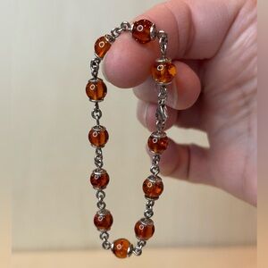 Silver toned and amber bracelet. 6 1/4 inches. Lobster claw clasp. Pre-owned